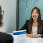 a woman sitting at a table with a piece of paper in front of her